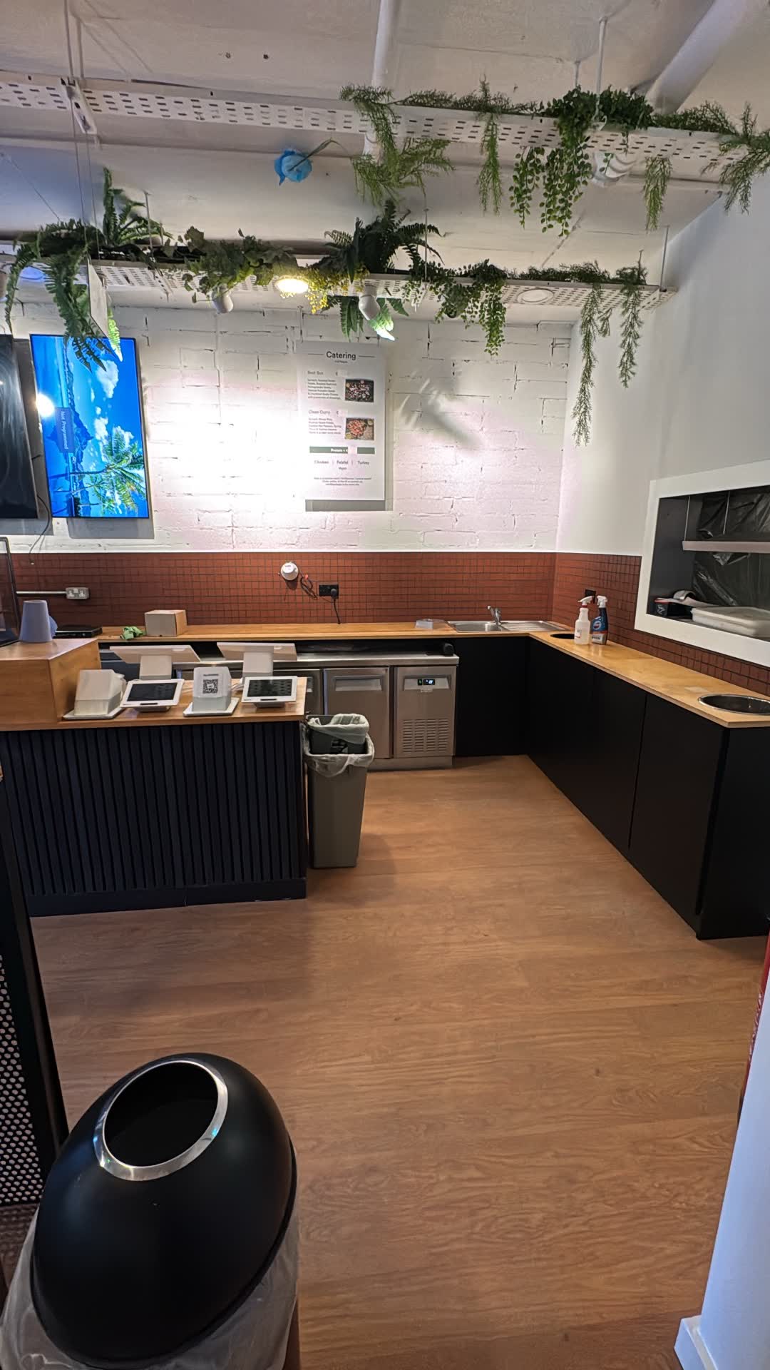 Behind the counter at Lean Bean Coffee showing equipment power supply, wall-mounted lighting, and tiled backsplash